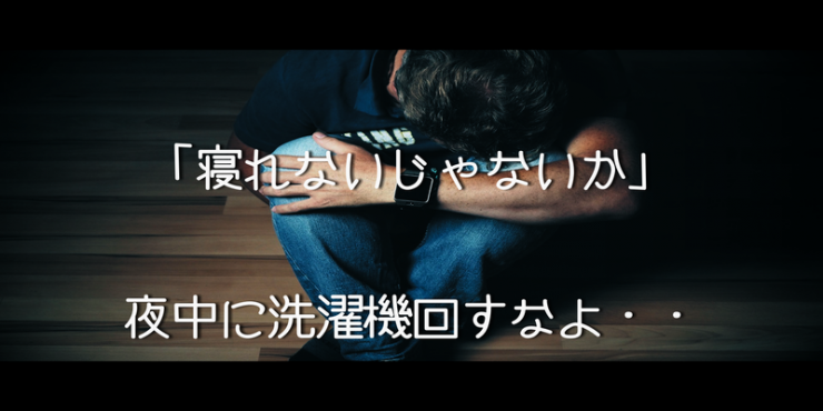 隣人に洗濯機を回されて、途方に暮れ膝を抱え込む男性の姿、時間帯は夜中